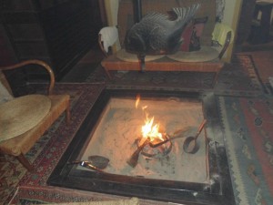 囲炉裏に薪をくべる。